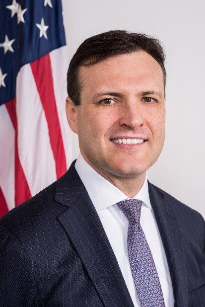 Headshot of C.J. Mahoney in front of a U.S. flag.